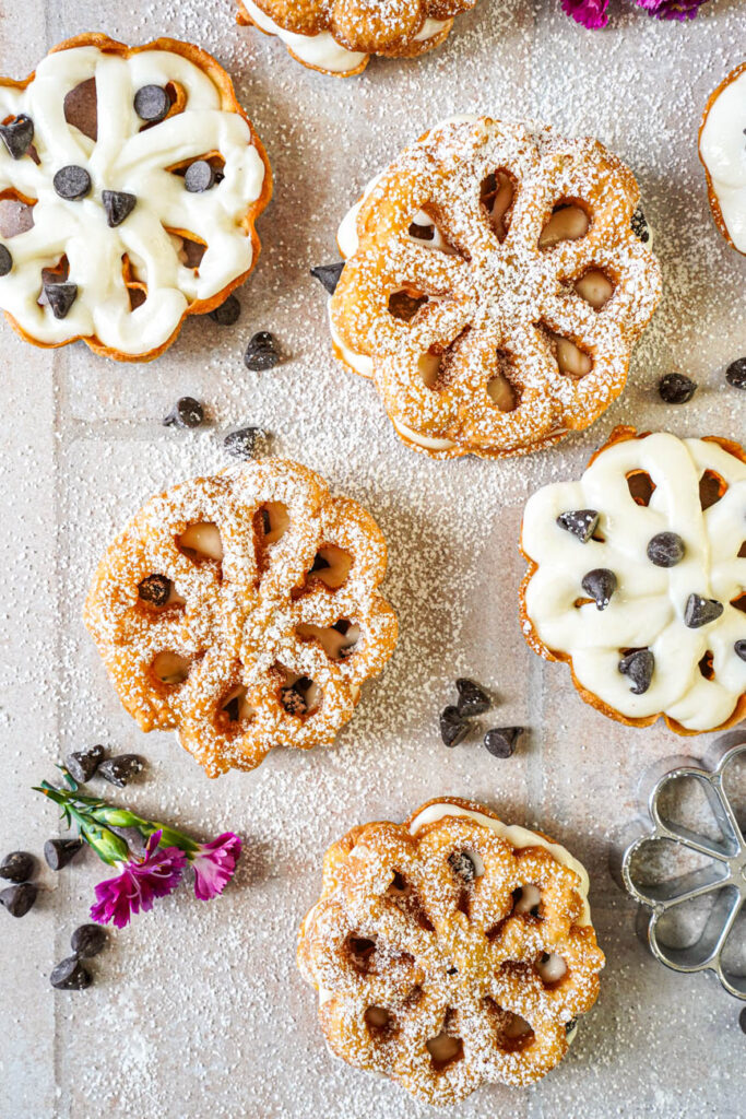 Aerial view of Baci Panteschi (Flower-Shaped Ricotta-Filled Pastries) filled with a sweet ricotta cream and chocolate chips.