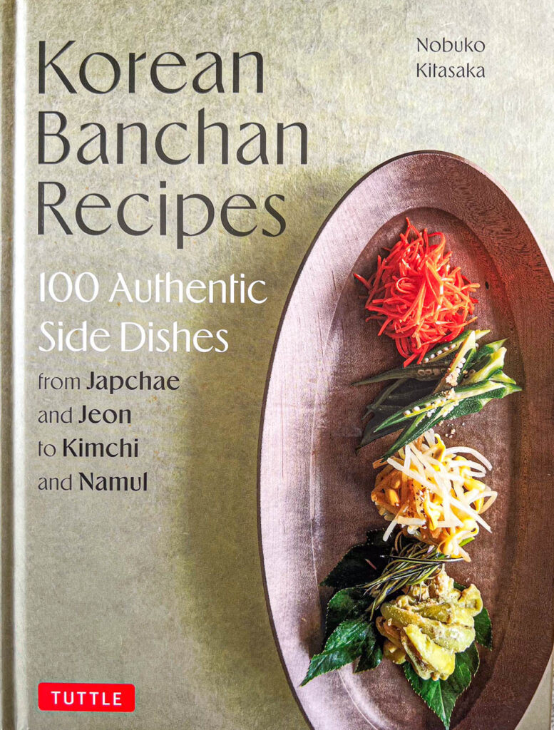 Cookbook cover- Korean Banchan Recipes: 100 Authentic Side Dishes from Japchae and Jeon to Kimchi and Namul.