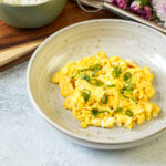 Miso Scrambled Eggs in a bowl with thinly sliced green onions.