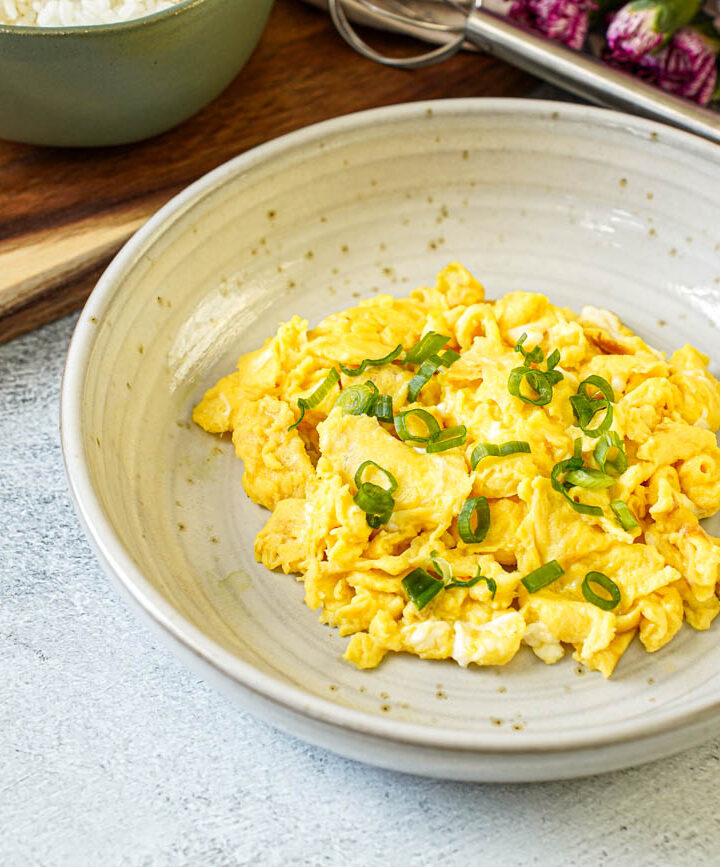 Miso Scrambled Eggs in a bowl with thinly sliced green onions.