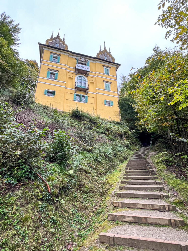 Yellow castle up a stone stair path.
