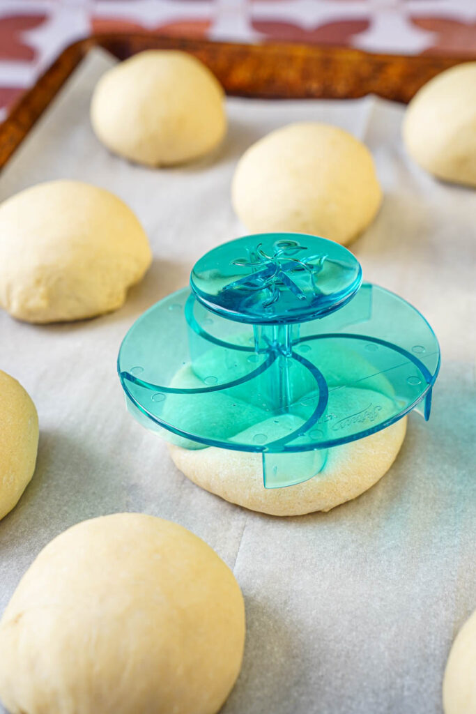 Pressing a blue star stamp into a round of dough.
