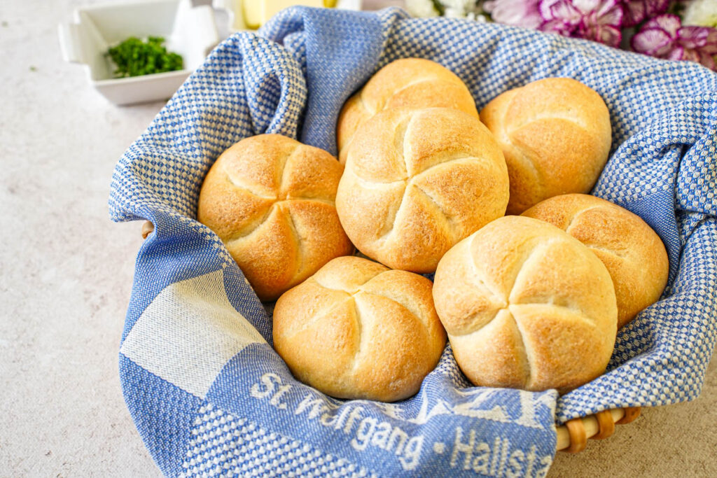 Kaisersemmel (Kaiser Rolls) in a basket with a blue towel.
