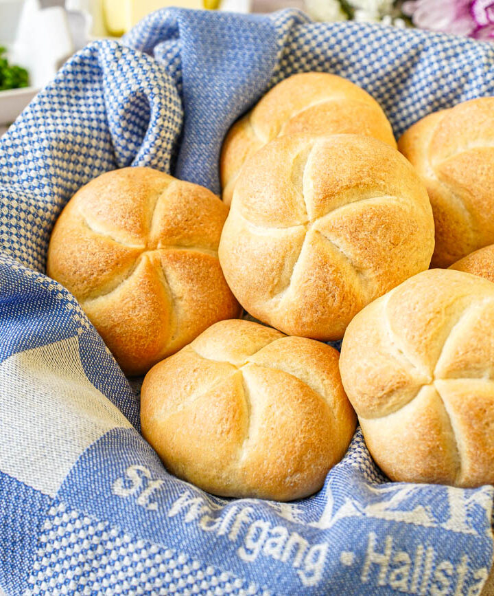 Kaisersemmel in a basket with a blue towel.