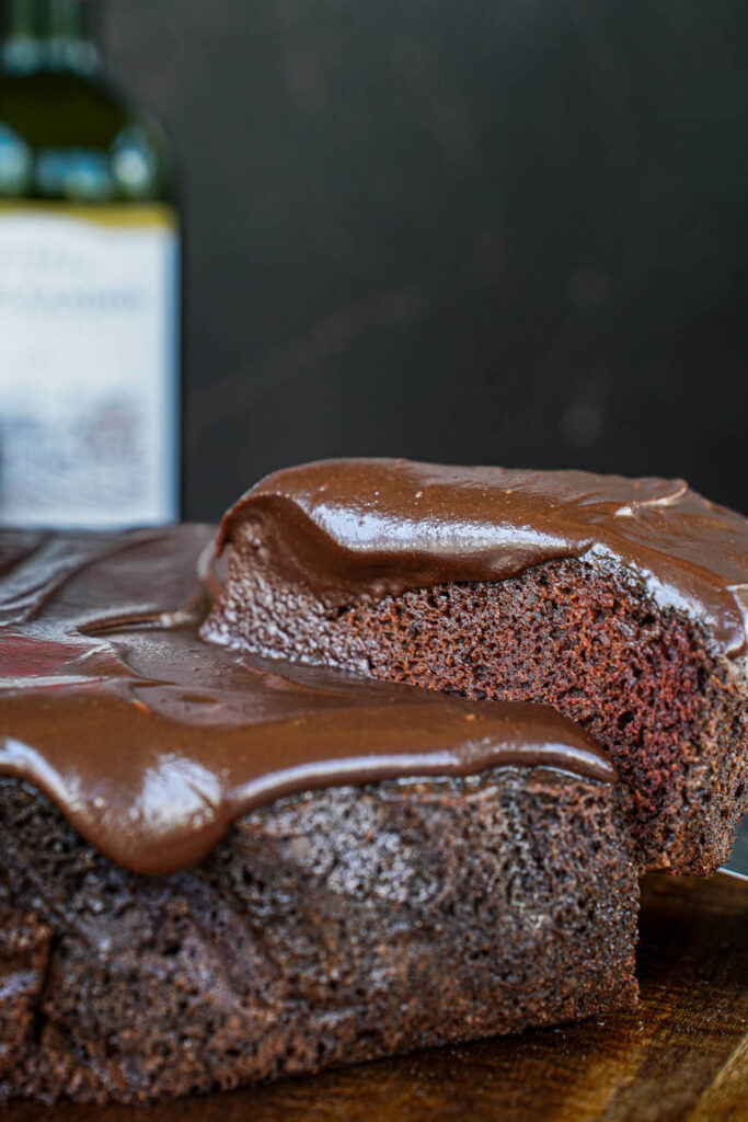 Side view of a slice of Red Wine Chocolate Cake lifting with a spatula.