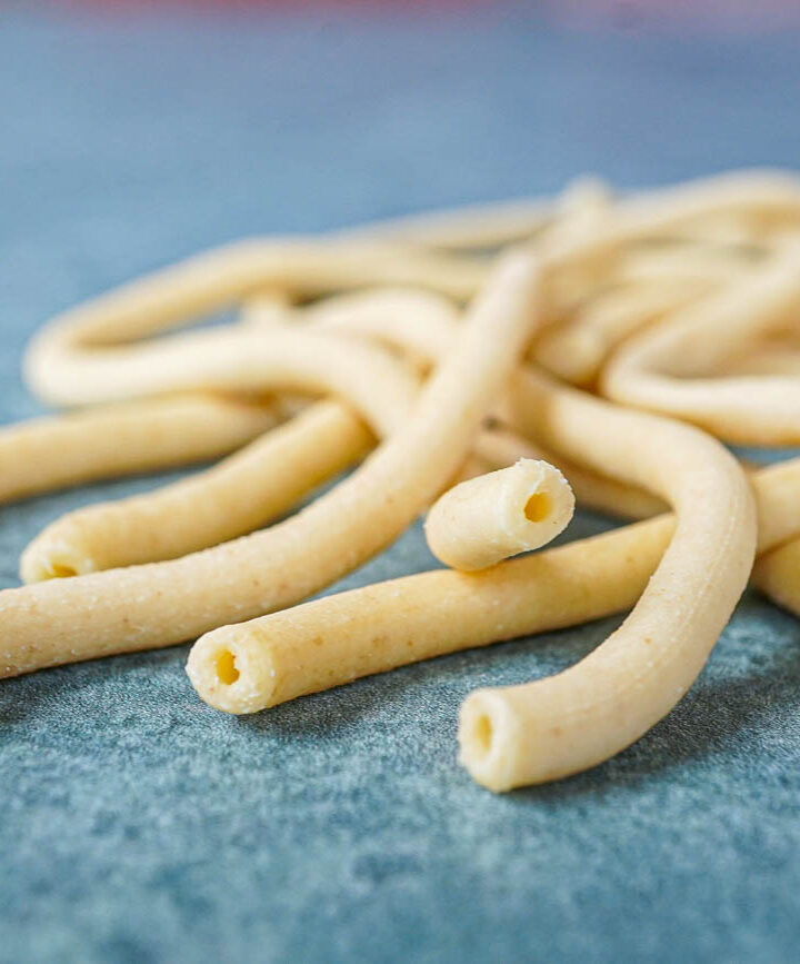 Bucatini noodles on a green background.