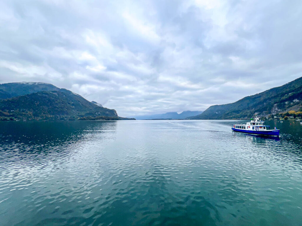 Ferry boat on Wolfgangsee with mountains on each side.