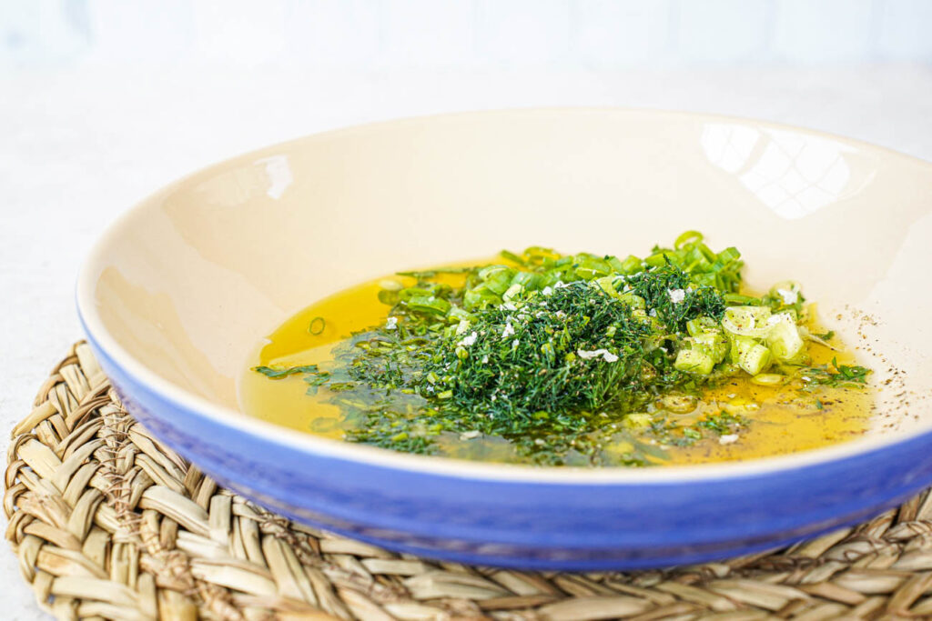 Dill, parsley, and spring onions in a pool of olive oil.