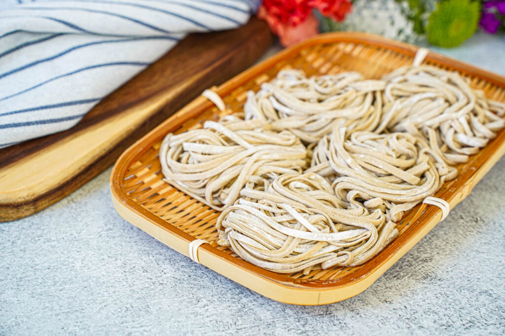 Five bundles of Homemade Soba in a bamboo basket.