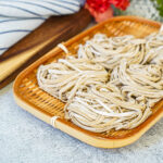 Five bundles of Homemade Soba in a bamboo basket.