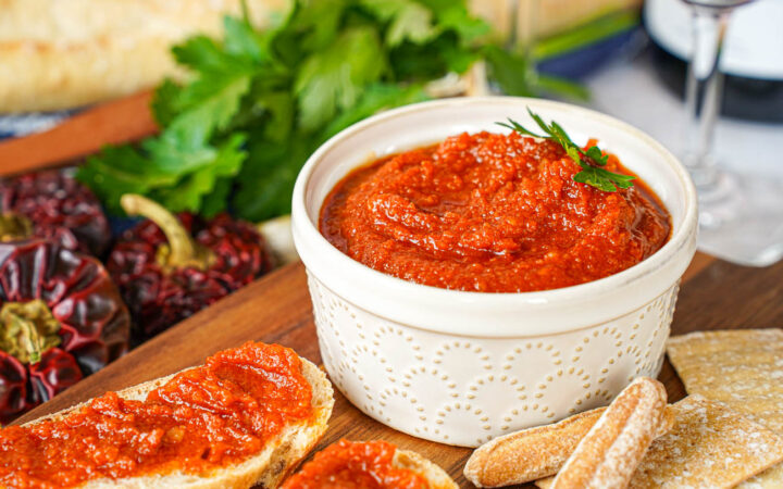 Almogrote (Canarian Cheese Pâté) in a ramekin next to crackers and bread slices topped with the cheese.