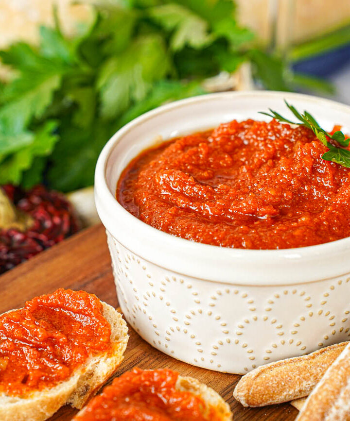 Almogrote (Canarian Cheese Pâté) in a ramekin next to crackers and bread slices topped with the cheese.