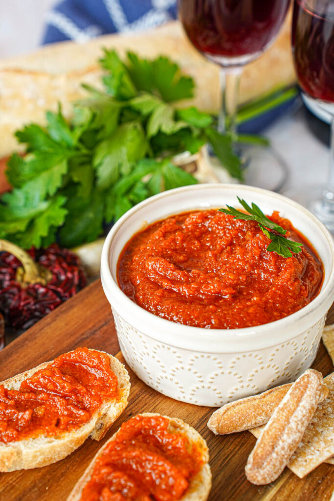 Almogrote (Canarian Cheese Pâté) in a bowl next to crackers and more spread over two bread slices.