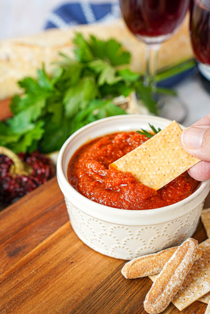 Dipping a cracker into a bowl of Almogrote (Canarian Cheese Pâté).