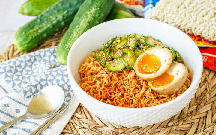 Korean Cucumber Salad Ramyeon in a white bowl with a halved egg.