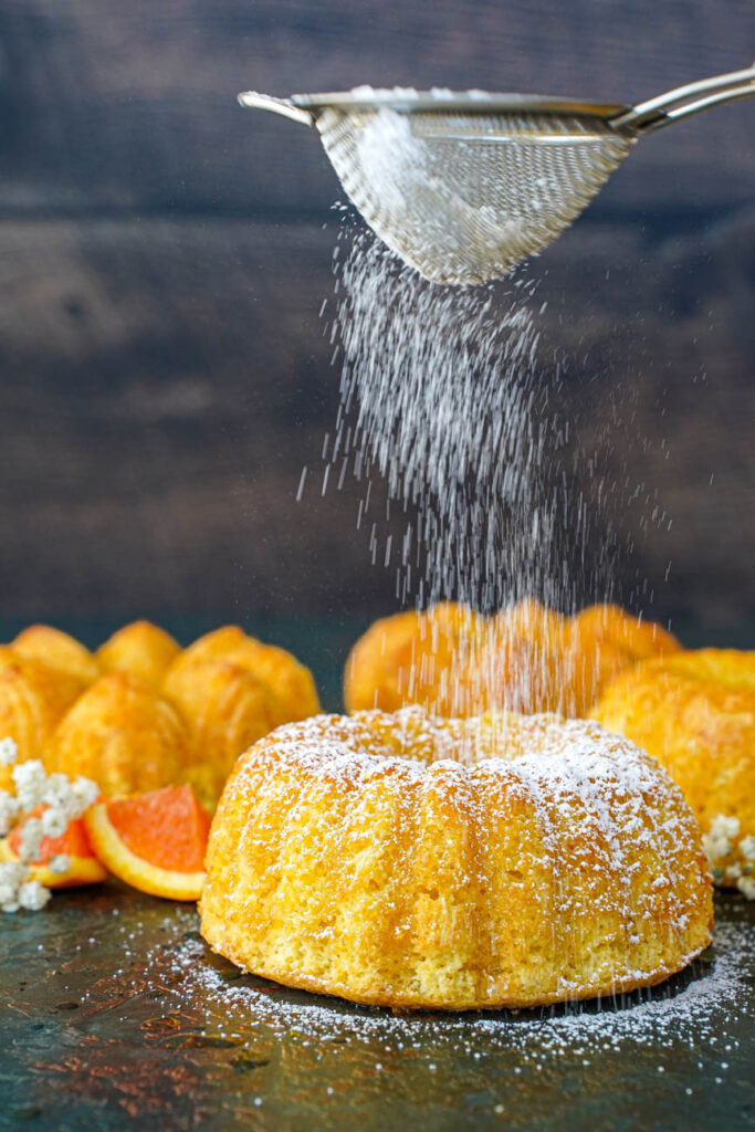 Dusting powdered sugar over Meskouta.