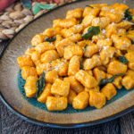 Pumpkin Ricotta Gnocchi on an oval tray with crisp sage leaves.