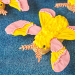 Rosy Maple Moth Cookies decorated with yellow and pink icing.