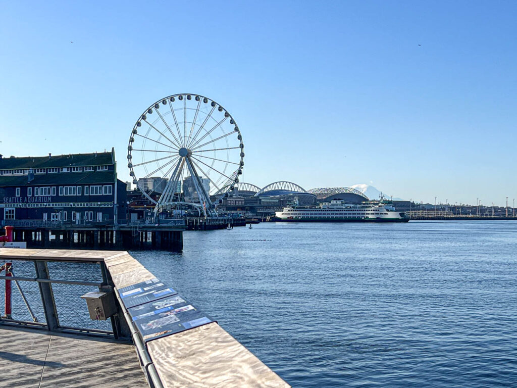 Ferris Wheel and mountain with view of water in Seattle.